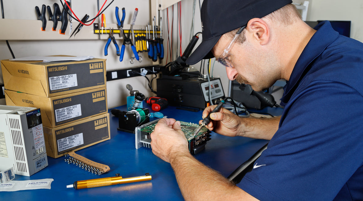 Technician repairing a circuit board at our Raleigh facility